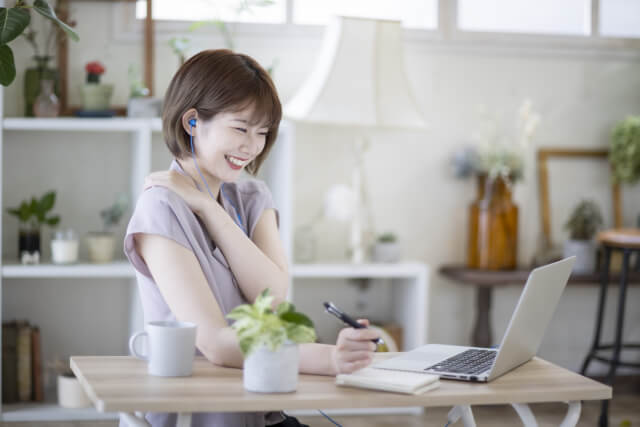 パソコンに向かって笑顔で話す女性